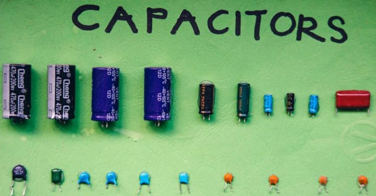 Electrolytes - Top view layout of various capacitors for storing electrical energy of different sizes and capacities arranged on green background with inscription
